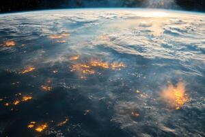 Earth's city lights at night with clouds and a sunbeam. photo
