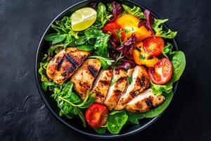 Grilled chicken breast with salad on black background photo