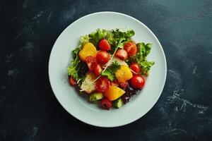 A plate with a salad on it with tomatoes, lettuce and other vegetables photo