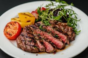Grilled steak with grilled vegetables on a white plate. photo