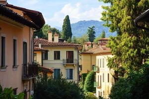 A quaint street lined with traditional Italian buildings, with mountains in the background. photo