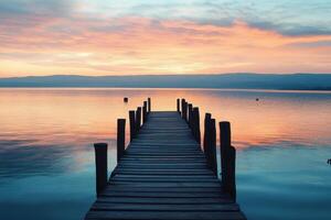 A wooden pier extends into a calm lake at sunrise. photo