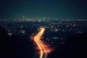 City lights and a winding road illuminate the night. photo