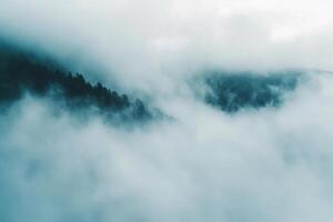 A view of a mountain covered in fog photo
