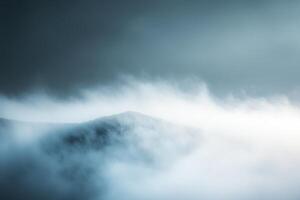 Misty mountain peak with a cloudy sky. photo