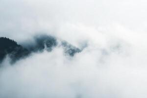 Misty mountain peak with clouds, aerial view. photo