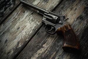 A revolver lies on a weathered wooden surface. photo