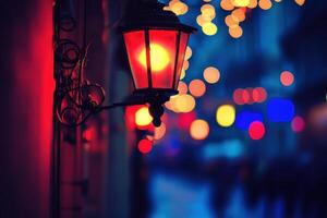 A red lantern illuminates a city street at night, with blurred lights and people in the background. photo