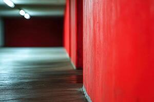 Red wall and concrete floor in an underground parking garage. photo