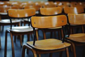 Rows of empty wooden chairs in an auditorium. photo