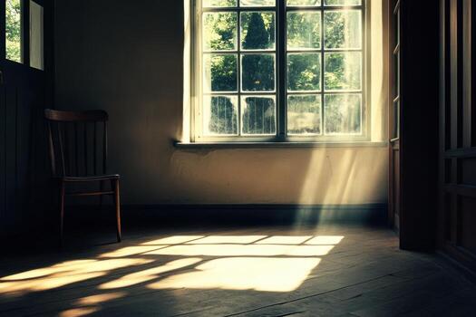Sunlight streams through a window into an empty room with a wooden chair. photo