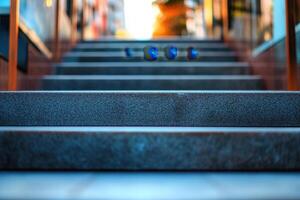 Closeup of grey concrete steps leading up to a brightly lit entrance. photo