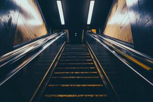 A dark and narrow staircase leading up to a bright exit. photo