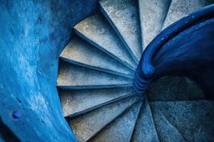 A spiral staircase painted in a vibrant blue. photo