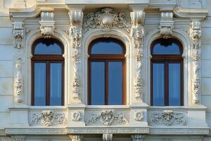 Ornate windows with stone carvings on a building facade. photo