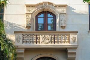 Ornate balcony with arched window and intricate stonework. photo