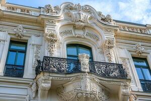 Ornate balcony with intricate stonework and wrought iron railing on a historic building. photo