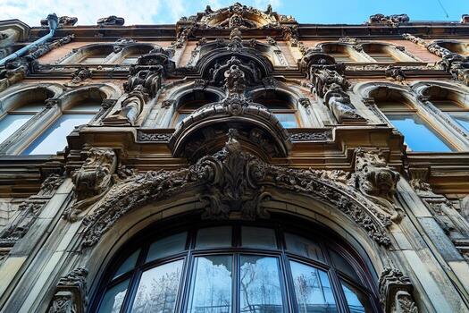Ornate architectural details on an old building facade with a large arched window. photo