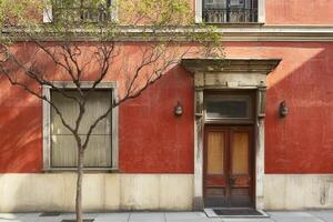Red brick building with wooden door and window. photo