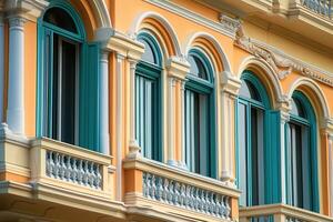 A row of arched windows with teal shutters on an orange building. photo