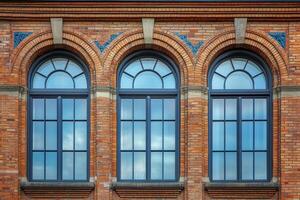 Three arched windows on a brick facade. photo