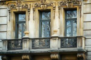 Three windows with ornate trim and balcony. photo