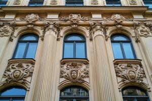 Ornate facade of an old building with arched windows and columns. photo