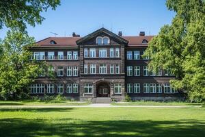 Historic brick building with symmetrical facade and green lawn. photo