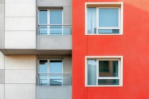 Modern building facade with red and grey walls and windows. photo