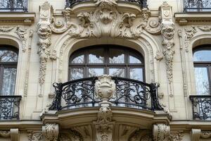 Ornate balcony with wrought iron railing and arched windows on a historic building. photo