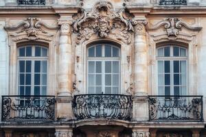 Ornate facade with three windows and a balcony. photo