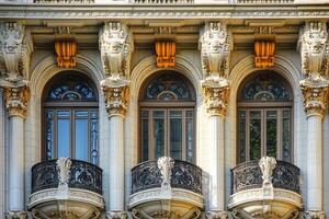 Ornate facade with three arched windows and balconies. photo