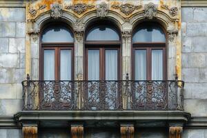 Three arched windows with a wrought iron balcony. photo