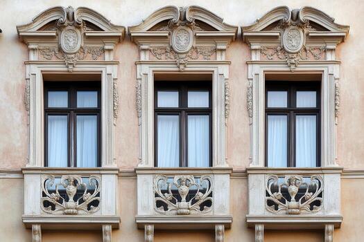 Three ornate windows with balconies on a building facade. photo
