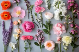 A flat lay of various colorful flowers on a gray background. photo