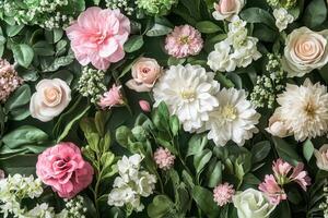 Flat lay of pink and white flowers with green leaves on a green background. photo