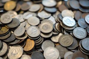 A pile of various coins in different denominations. photo