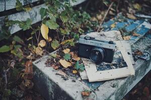 Vintage camera on a bench with old photographs. photo