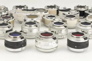 A collection of various camera lenses arranged on a white surface. photo