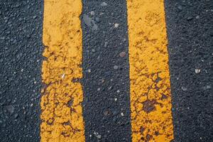 Two parallel yellow lines on asphalt road. photo