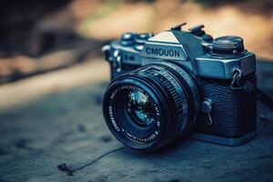 Vintage silver camera with lens on a wooden surface. photo