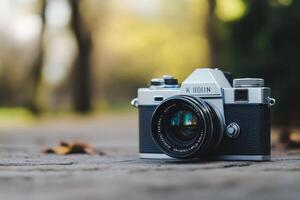 Vintage film camera resting on a paved surface in a natural setting. photo