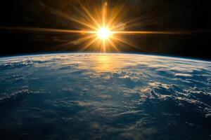 A breathtaking sunrise over Earth, seen from space. The sun's rays illuminate the clouds and create a beautiful glow over the planet. photo