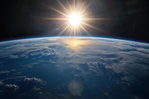 A bright, shining sun rises over the Earth, casting its light on the planet's clouds and atmosphere. photo