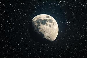 A close-up of a gibbous moon in a starry night sky. photo
