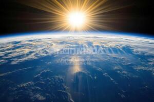 A stunning sunrise from space, showing Earth with a glowing sun and clouds. photo