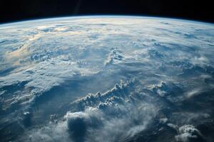 Earth's Atmosphere viewed from space, showing a vast expanse of white clouds illuminated by the sun. photo
