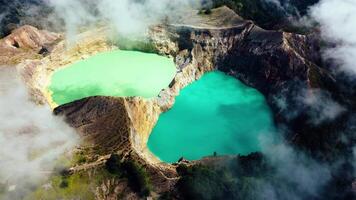 Experience the mesmerizing of Kelimutu's Three Color Lake in Ende. Wrapped in mystical clouds, this magical site, rich in legend, offers a breathtaking landscape that captivates the soul. video