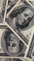 Background with One Hundred Dollar Bills on a Rotating Platform. Stack of cash. Close-up, vertical footage video