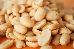 This is a CloseUp Image of Shelled Peanuts on a Beautifully Designed Wooden Surface photo